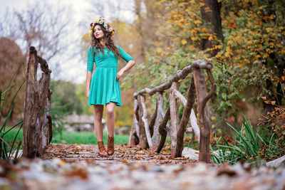 Full length of woman standing by tree