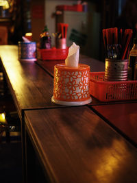 High angle view of tissue paper and eating utensils in container on table at restaurant