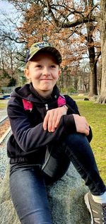 Portrait of boy sitting in park during winter