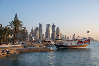 Boats in sea against clear sky