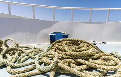 Close-up of rope tied on metal against sky