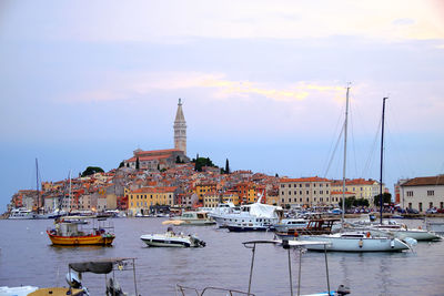 Boats moored at harbor against sky