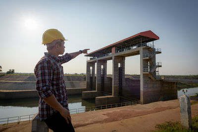 Man standing at construction site against sky