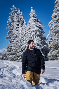 Full length of young man on snowcapped mountain against sky