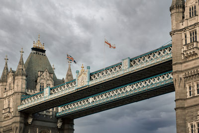 Low angle view of bridge against cloudy sky
