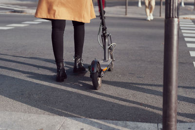 Low section of woman with push scooter