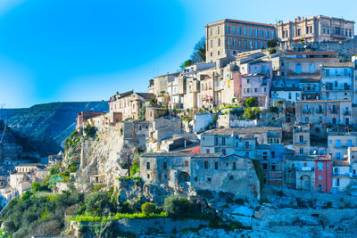 Buildings in city against blue sky