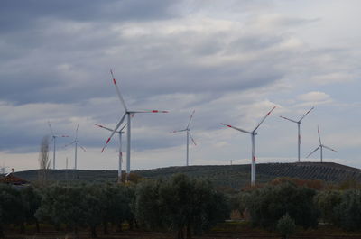 Wind turbines on land against sky