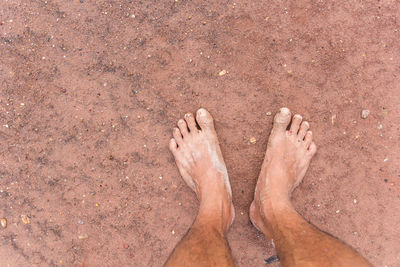 Low section of woman on sand