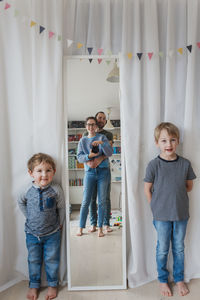 Boys looking at parents reflecting in mirror