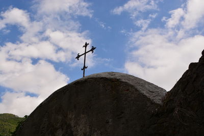 Low angle view of weather vane against sky