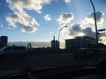 Cars on road with buildings in background