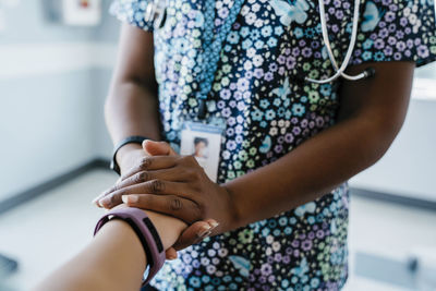 Close-up of pediatrician comforting girl in medical examination room