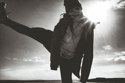 Silhouette of woman standing against sky