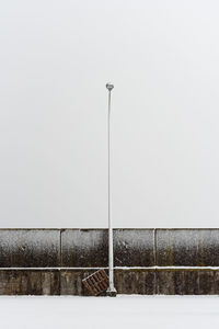 Street light on field against clear sky during winter