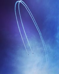 Low angle view of vapor trail against blue sky