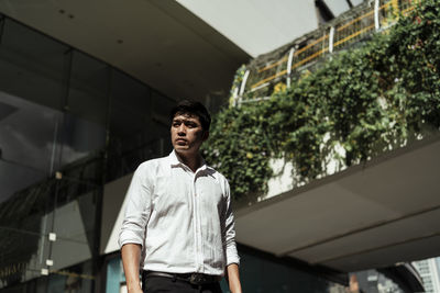 Low angle view of businessman standing in city