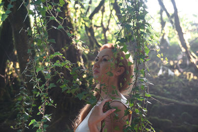 Person holding plant by tree