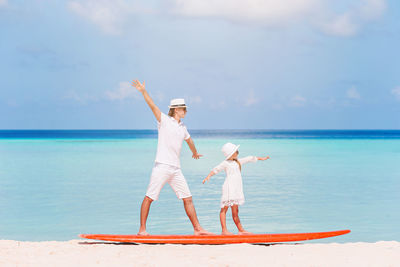 Woman with umbrella on beach against sky