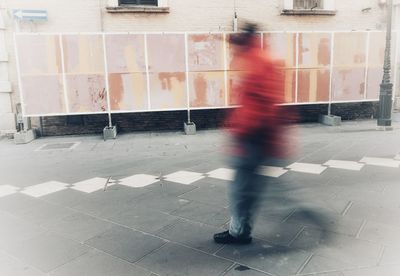 Blurred motion of woman walking on road