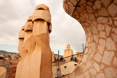 Statue in city against sky