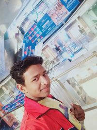 Portrait of young man looking away while standing in store