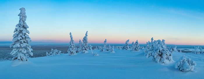 Scenic view of frozen landscape against blue sky