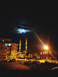 Illuminated buildings against sky at night