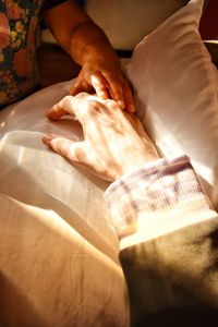 Midsection of woman hand on bed