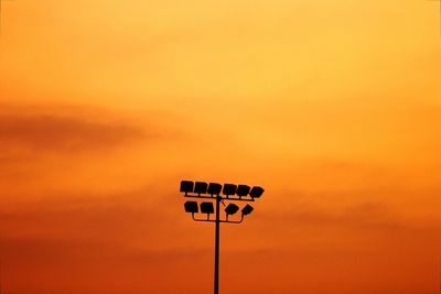 Low angle view of street light against orange sky