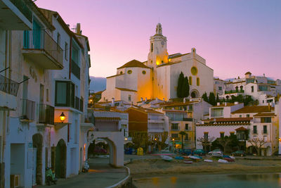 Buildings in city against clear sky during sunset