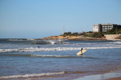 Lighthouse on shore against blue sky