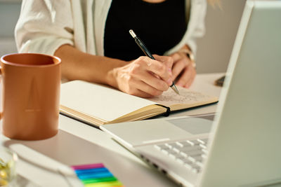 Illustrator drawing sketches in notebook at home office desk