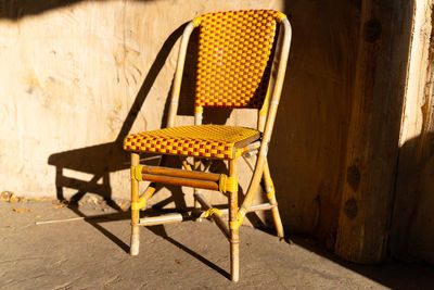 Empty chairs and table against wall