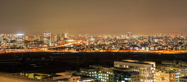 High angle view of illuminated city buildings at night