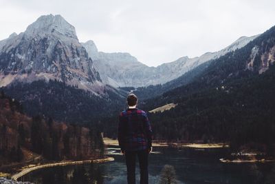 Man standing on rock by lake