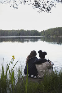 Female friends embracing at lakeshore