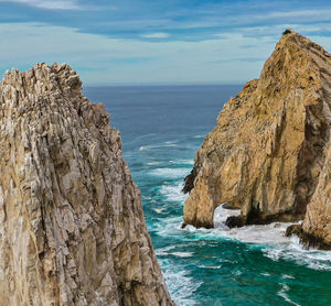 Scenic view of rock formation in sea against sky