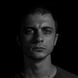 Portrait of young man against black background