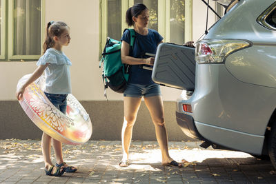 Side view of woman holding car