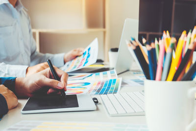 Midsection of man using laptop on table