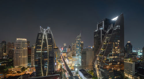 Illuminated buildings in city against sky at night