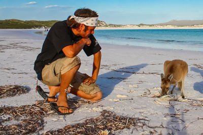 Young man looking at kangaroo on shore