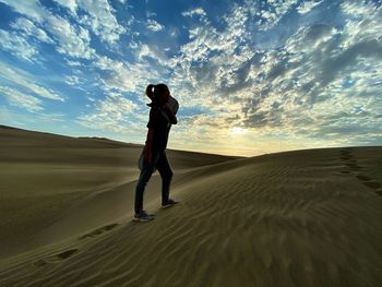 Full length of man on sand at beach against sky