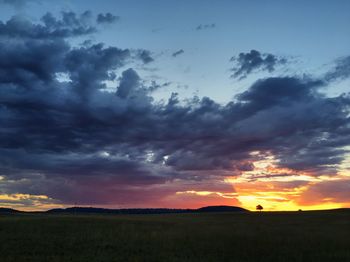 Scenic view of dramatic sky over land during sunset