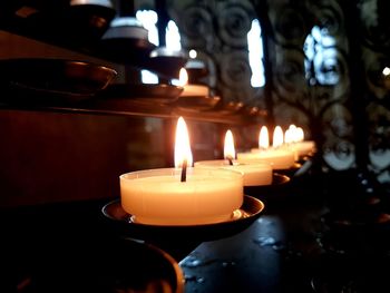 Close-up of lit candles in temple