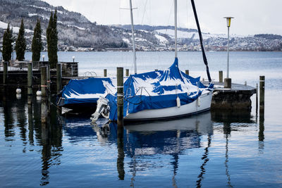 Sailboats moored in lake during winter