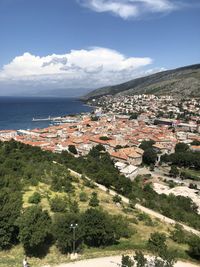 Aerial view of townscape by sea against sky