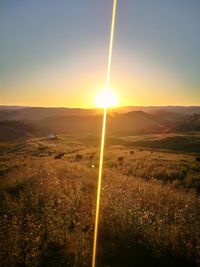 Scenic view of field against sky during sunset
