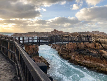 Bridge over sea against sky during sunset